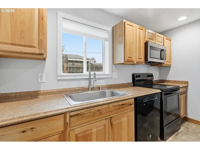 a kitchen with stainless steel appliances granite countertop a refrigerator a stove and a sink