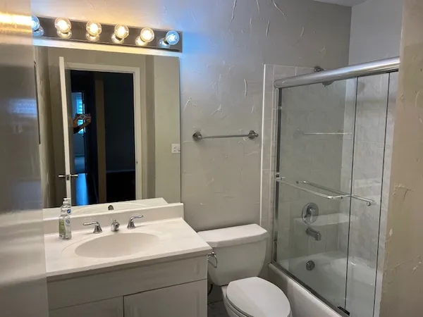 a bathroom with a toilet a sink and shower