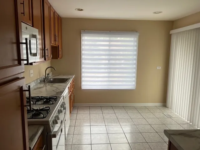 a kitchen with a sink a stove cabinets and a window