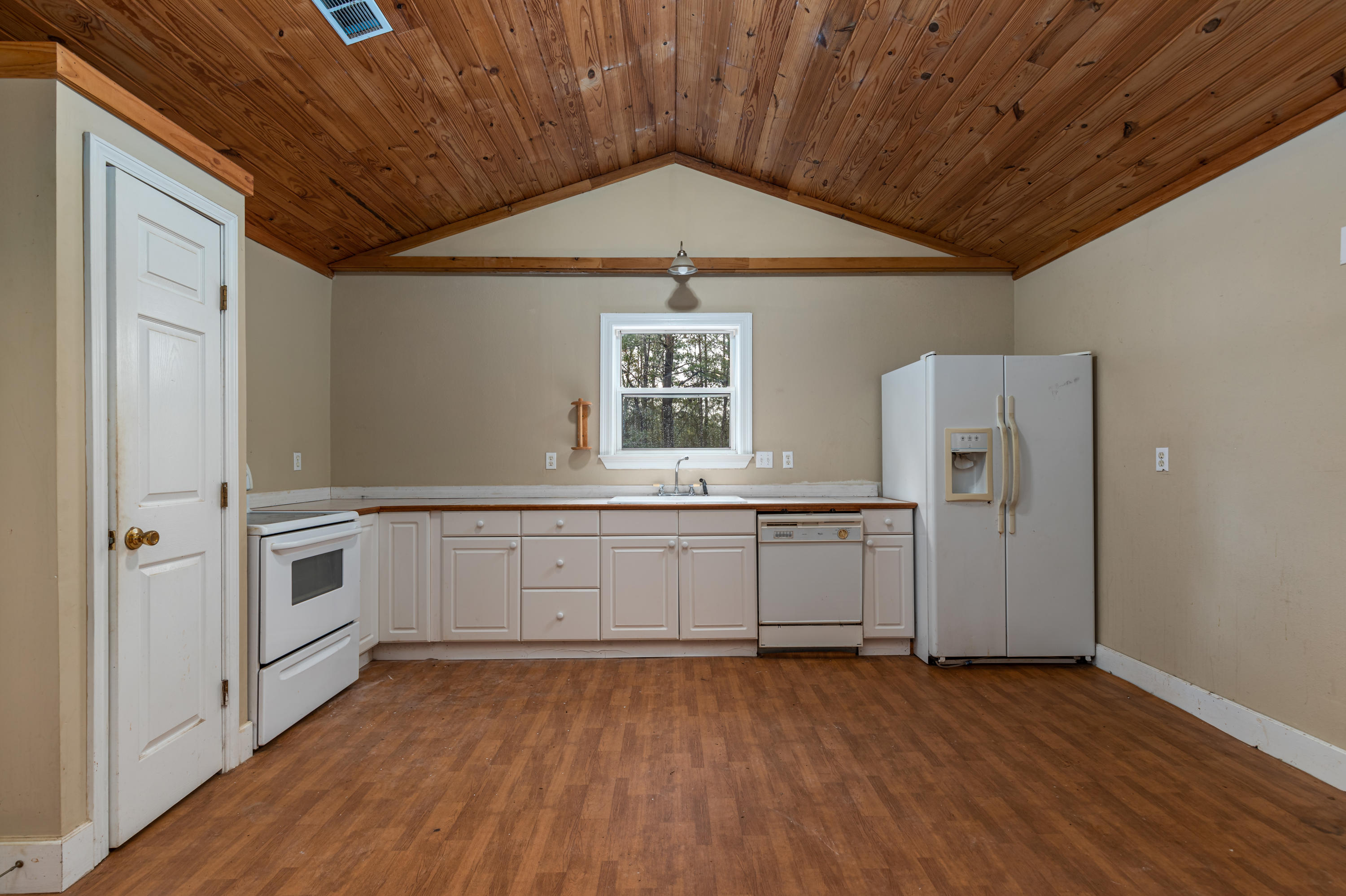 1504 Hinote Road DeFuniak Springs, FL 32433 - Photo 3 of 21 a kitchen with granite countertop white cabinets and wooden floor