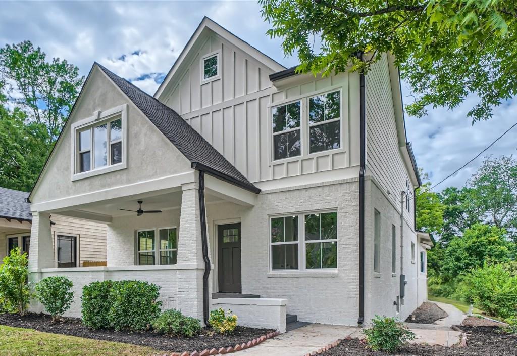 a view of a white house next to a yard