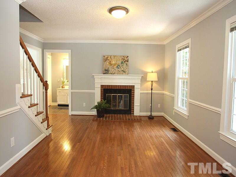 4 Swallows Ridge Court Durham, NC 27713 - Photo 2 of 18 an empty room with wooden floor fireplace and windows