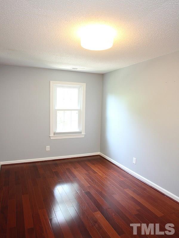 4 Swallows Ridge Court Durham, NC 27713 - Photo 11 of 18 a view of an empty room with wooden floor and a window