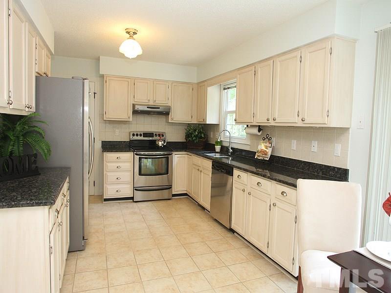 4 Swallows Ridge Court Durham, NC 27713 - Photo 6 of 18 a kitchen with granite countertop white cabinets and white appliances