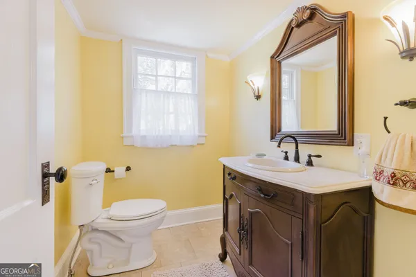 a bathroom with a toilet sink and mirror