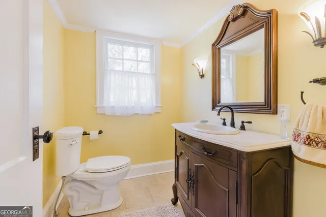 a bathroom with a toilet sink and mirror