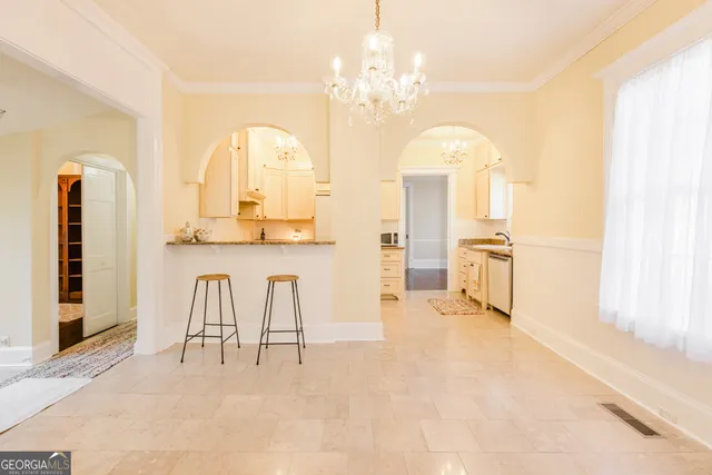 a view of a livingroom with a chandelier fan and windows