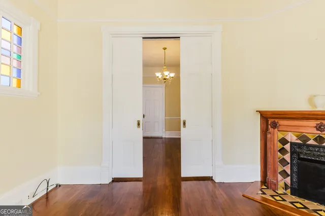 a view of a room with wooden floor and chandelier