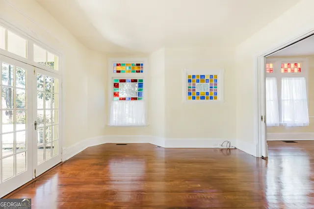 a view of empty room with window and wooden floor