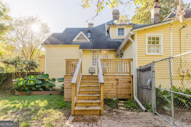 a front view of a house with a yard outdoor seating and covered with trees