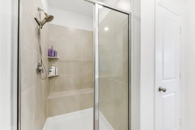a spacious en suite bathroom with a double vanity sink and mirror