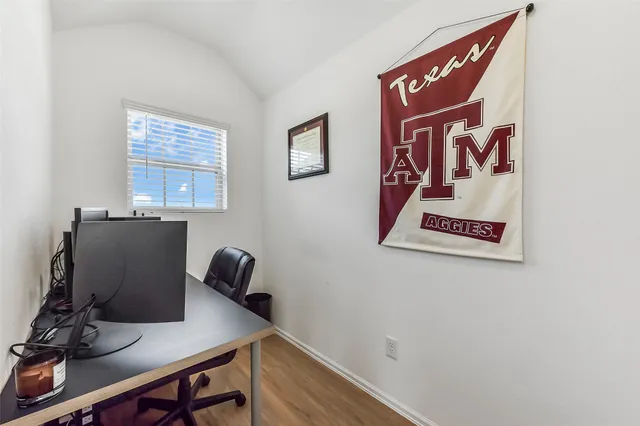 a view of a workspace with furniture and a window