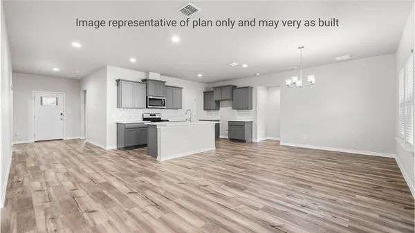 a view of kitchen with kitchen island a sink wooden floor and stainless steel appliances