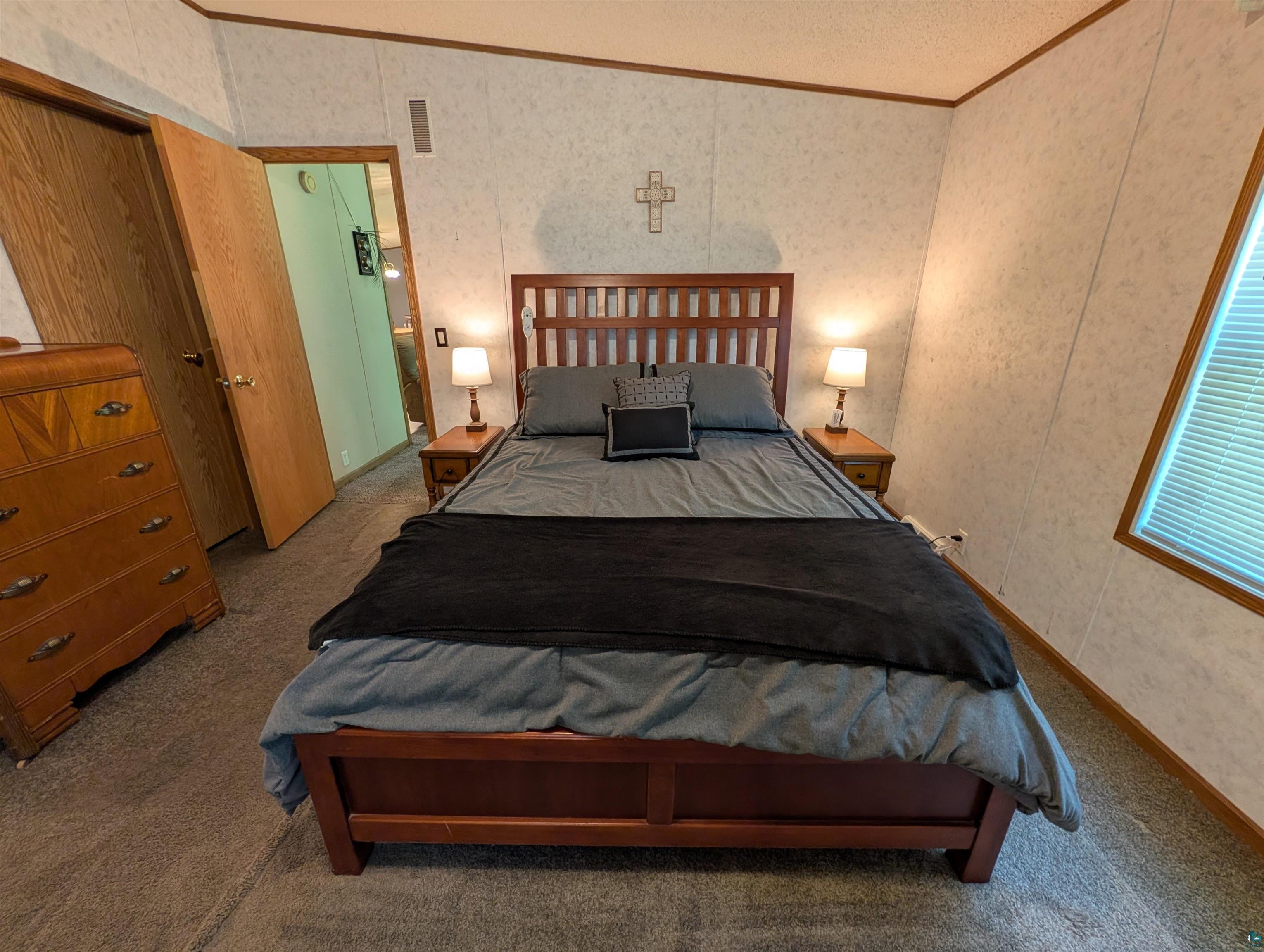 3945 Maple Street Kettle River, MN 55757 - Photo 15 of 41 Carpeted room with a window featuring blinds, light-toned wall panels, and wood-finish trim