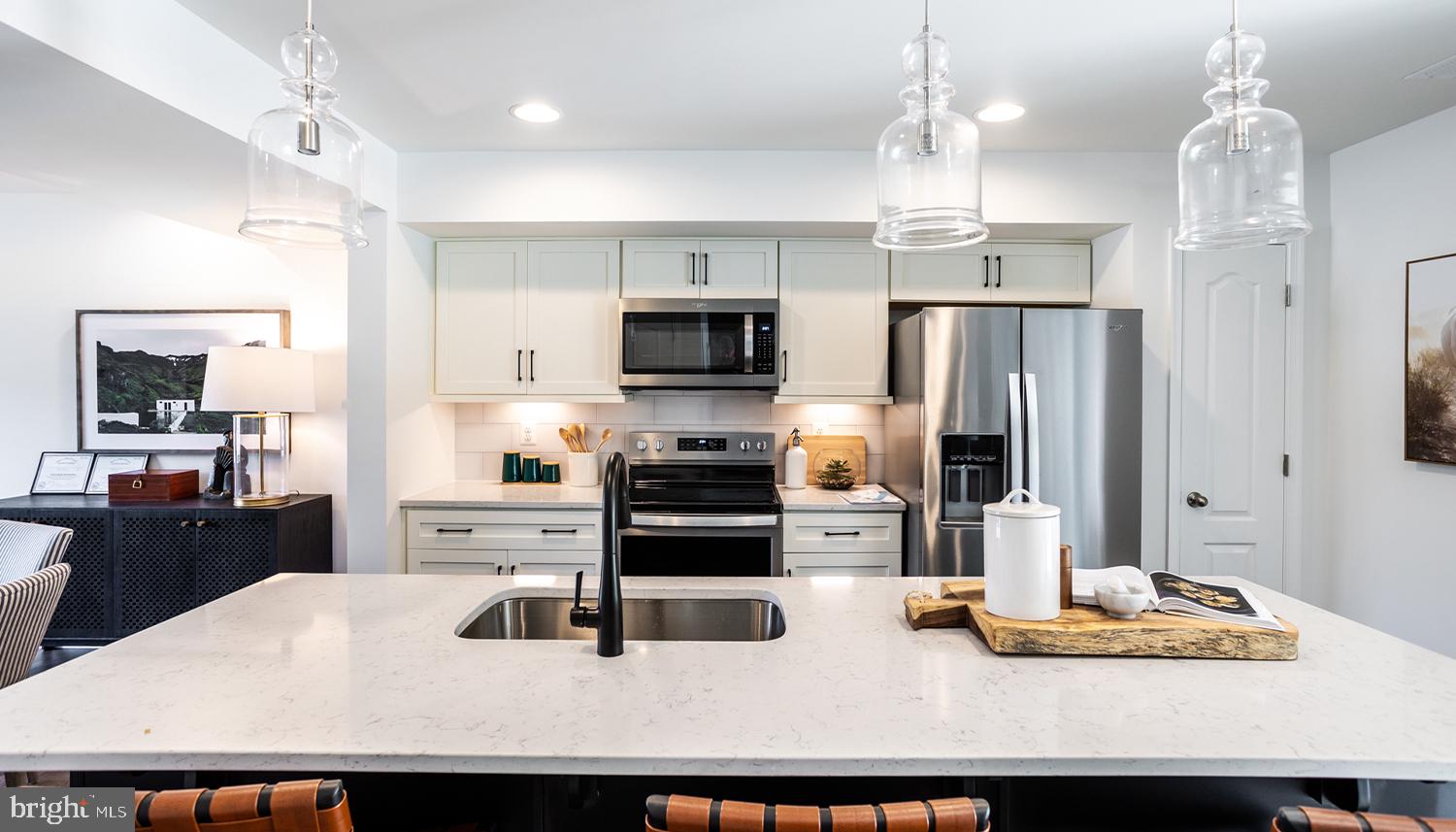 a kitchen with stainless steel appliances kitchen island granite countertop a sink refrigerator and microwave