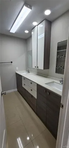 a spacious bathroom with a double vanity sink a large mirror and a shower