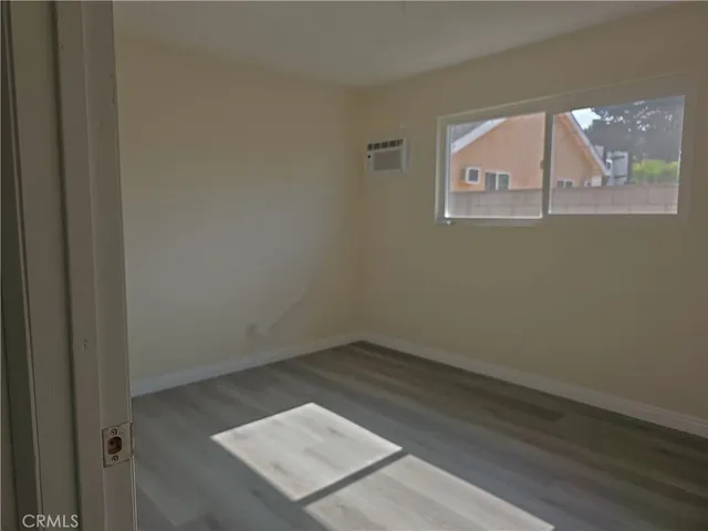 an empty room with chandelier fan and windows