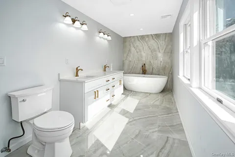 a bathroom with a toilet sink and mirror