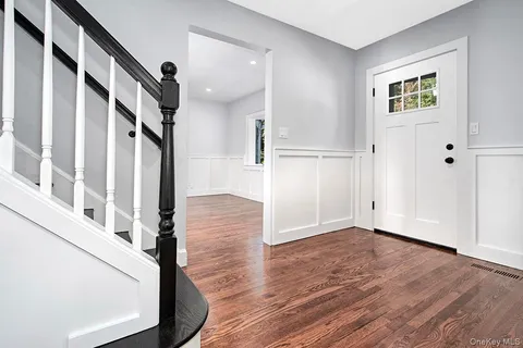 a view of an entryway with wooden floor and stairs
