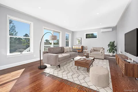 a living room with furniture large window and flat screen tv