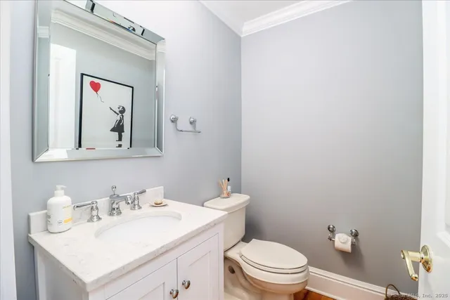 a bathroom with a toilet a sink and mirror