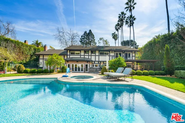 a house view with swimming pool and garden space
