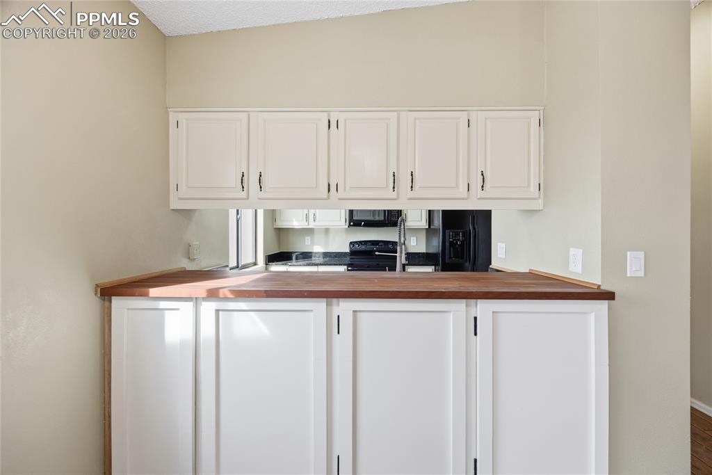 930 Fontmore Road, Unit C Colorado Springs, CO 80904 - Photo 12 of 32 a kitchen with stainless steel appliances granite countertop a sink a stove and white cabinets