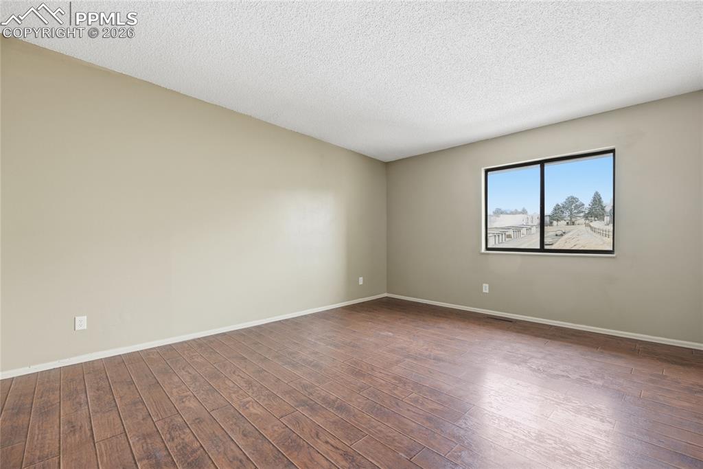 930 Fontmore Road, Unit C Colorado Springs, CO 80904 - Photo 15 of 32 a view of an empty room with wooden floor and a window