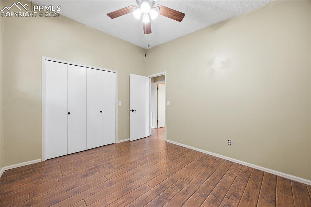930 Fontmore Road, Unit C Colorado Springs, CO 80904 - Photo 23 of 32 an empty room with wooden floor and a ceiling fan