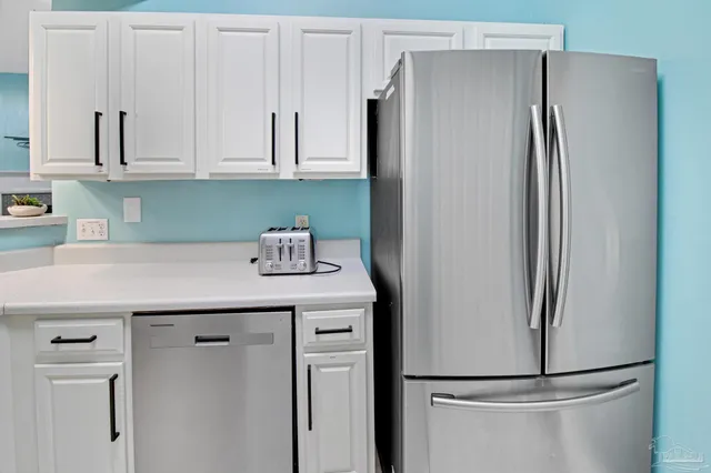 a kitchen with stainless steel appliances a refrigerator and cabinets