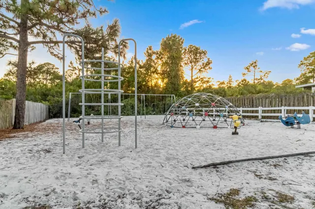 a view of a house with a small yard and wooden fence
