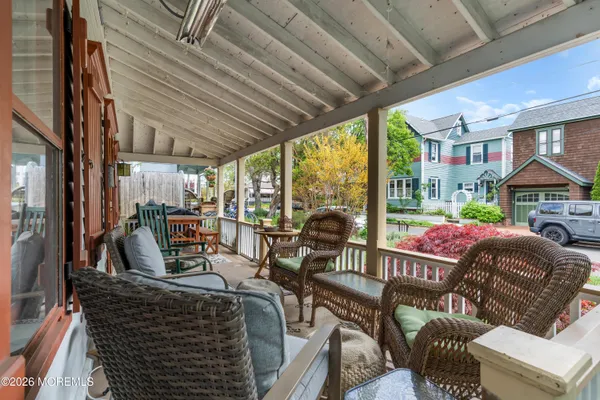 a view of a patio with couches chairs and wooden floor
