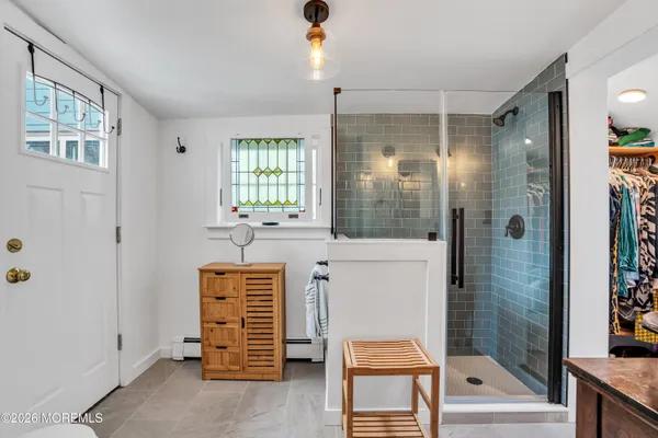 a bathroom with a shower a sink and a mirror