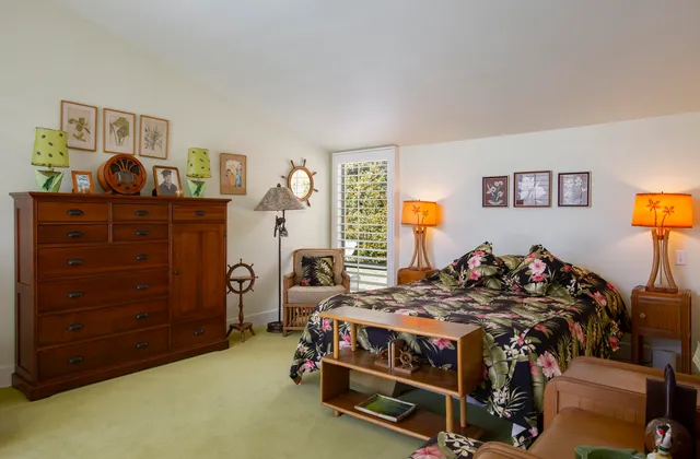 a bedroom with a bed and large windows