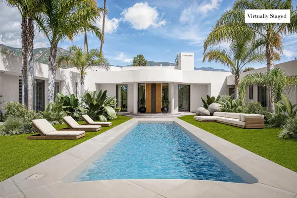 a view of a house with swimming pool and sitting area