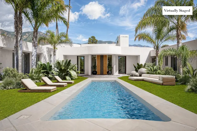 a view of a house with swimming pool and sitting area