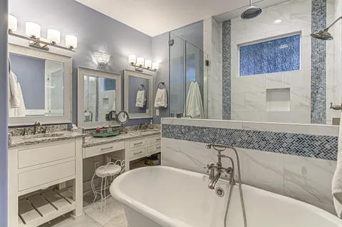 a bathroom with a tub sink and mirror