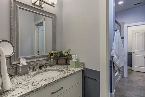 a bathroom with a granite countertop sink and a mirror