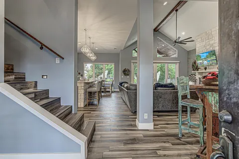 a living room with furniture a flat screen tv and a floor to ceiling window