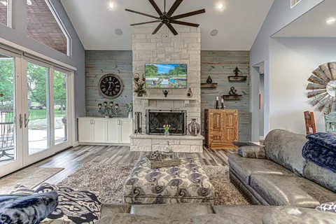 a living room with furniture a fireplace and a floor to ceiling window