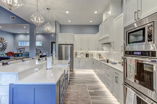 a large kitchen with stainless steel appliances kitchen island granite countertop a large stove a sink dishwasher and a microwave with wooden floor