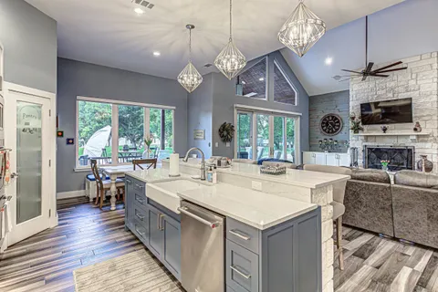 a large kitchen with kitchen island a large island in the center and stainless steel appliances