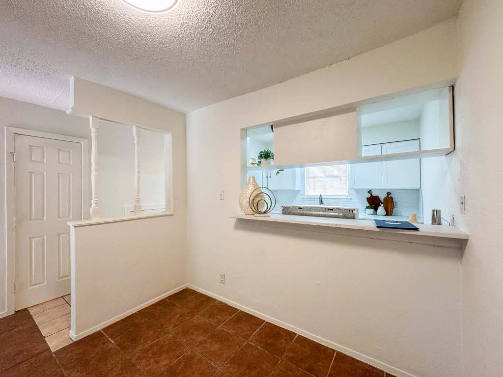 5810 Sweeney Circle, Unit D Austin, TX 78723 - Photo 11 of 18 Spare room with a textured ceiling and dark tile patterned floors