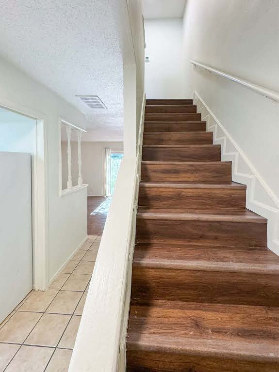 5810 Sweeney Circle, Unit D Austin, TX 78723 - Photo 13 of 18 Staircase featuring a textured ceiling and tile patterned flooring