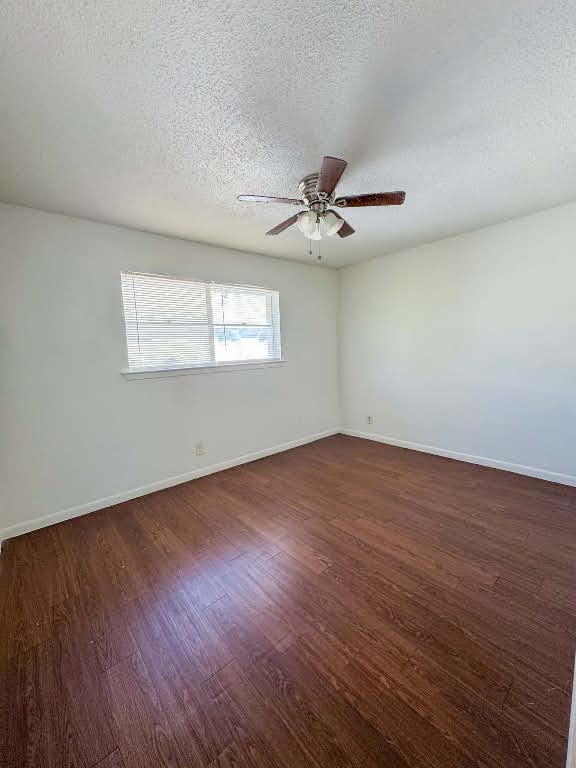 5810 Sweeney Circle, Unit D Austin, TX 78723 - Photo 15 of 18 Spare room featuring dark wood-style flooring, a textured ceiling, and a ceiling fan
