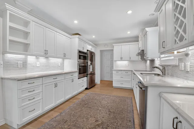 a kitchen with white cabinets stainless steel appliances and sink
