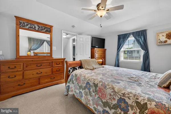 a bedroom with a bed and a dresser with mirror