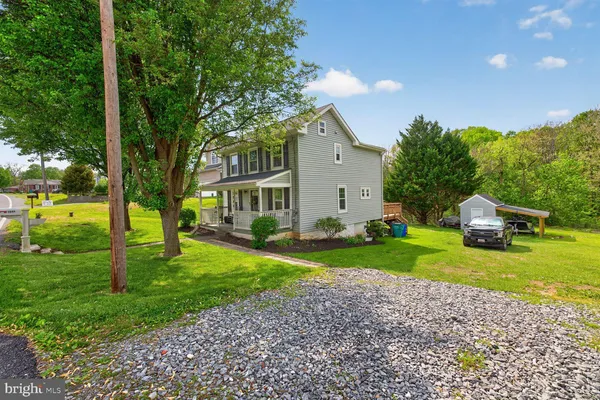 a view of a house with backyard and trees