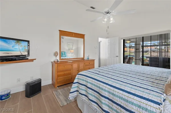 a bedroom with a bed dresser and a large window