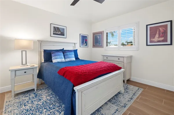 a spacious bedroom with a bed and wooden floor